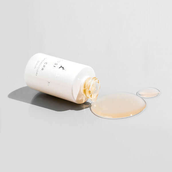 CPR skin recovery bottle on it's side with serum around it. It is an ultra-soothing Skin Recovery Serum